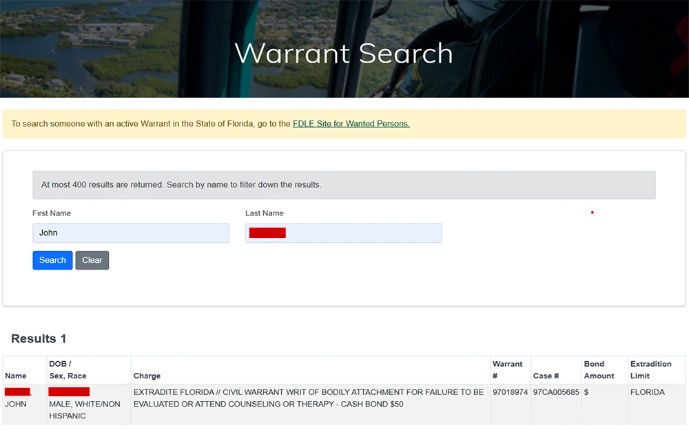 A screenshot from the Lee County Sheriff's Office website displaying the warrant search page with a search criteria field for full name and below it shows one result that includes information such as name, date of birth, sex, race, charges, warrant number, case number, bond amount, and extradition limit.